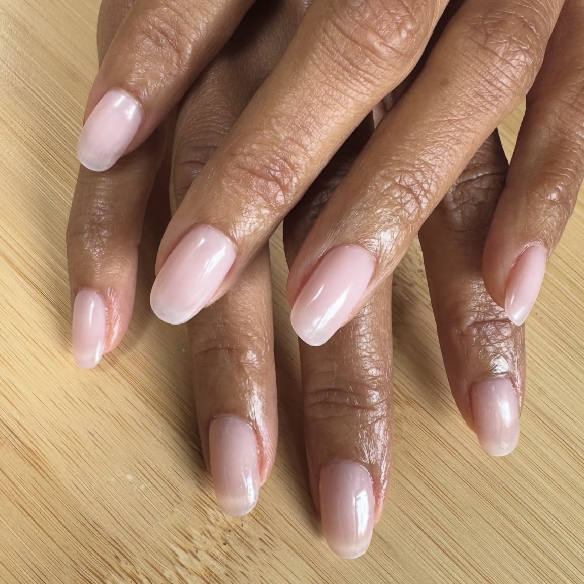 A pale pink and glossy nude manicure.