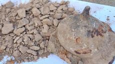 A cone-shaped stone container is full of gray ashes. 