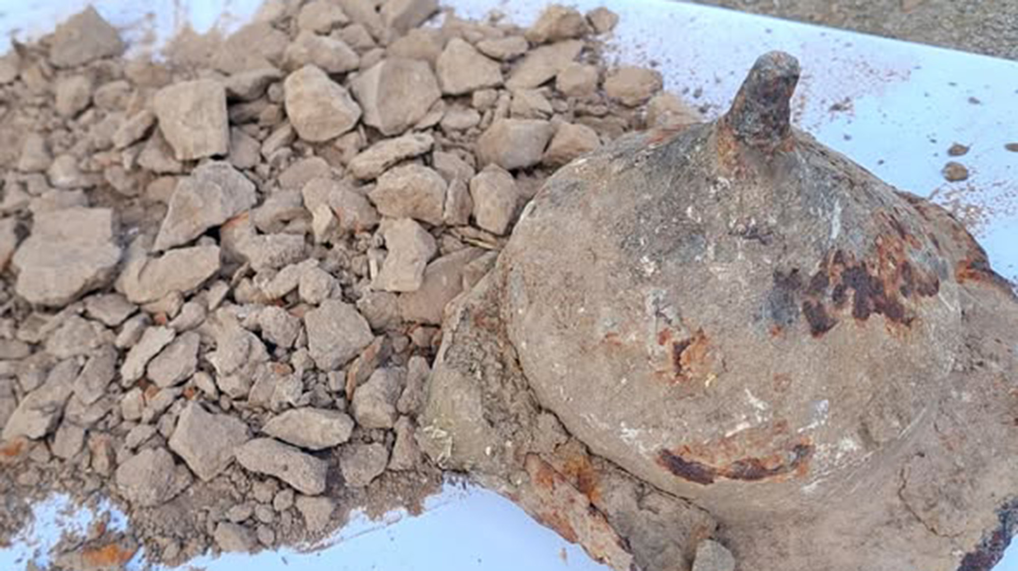 A cone-shaped stone container is full of gray ashes. 