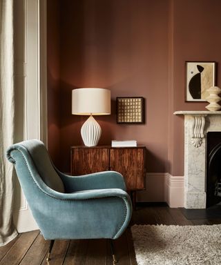 A brown living room with a blue velvet armchair