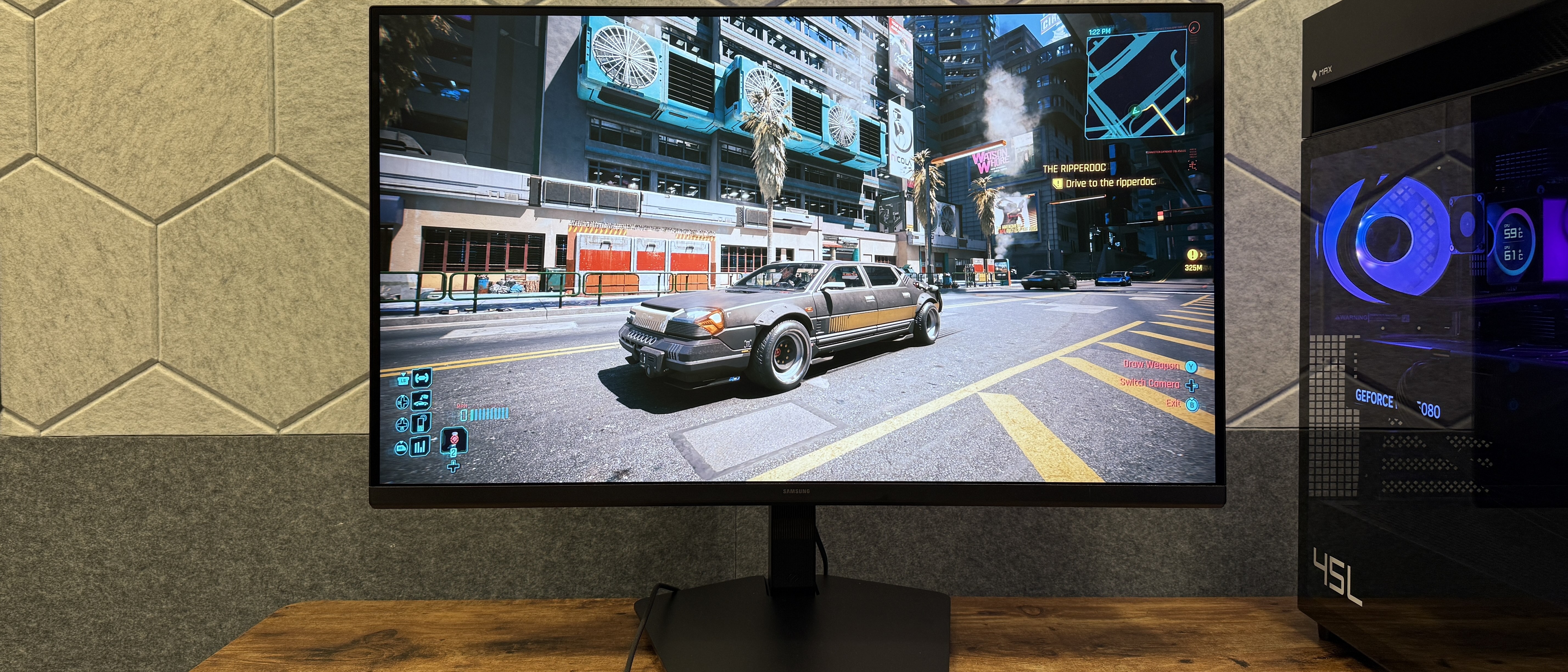 The Samsung Odyssey G8 (G80HS) gaming monitor running Cyberpunk 2077 next to a HP Omen Max desktop PC