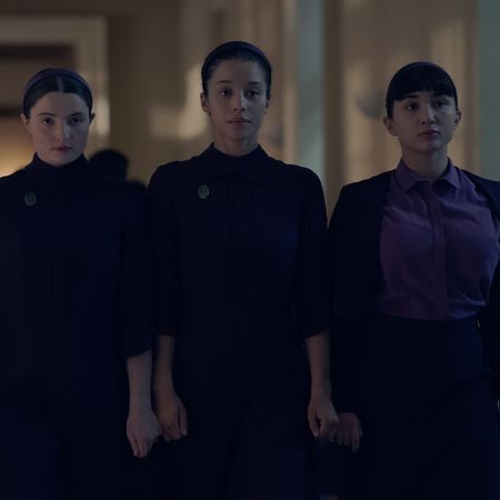 three girls including lucy halliday chase infiniti and rowan blanchard wear dark purple dresses walking down a hall in the testaments season 1 finale