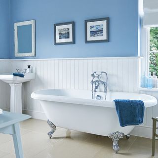 bathroom with bathtub and purple wall with towel