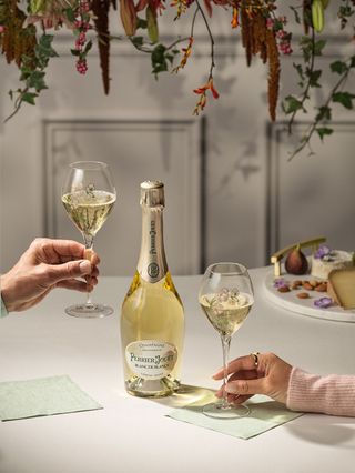 A bottle of Perrier Jouet blanc de blanc and two Perrier Jouet glasses