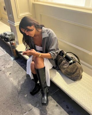 Boot Trends 2024: @sandrashehab wears a pair of moto boots with a white dress