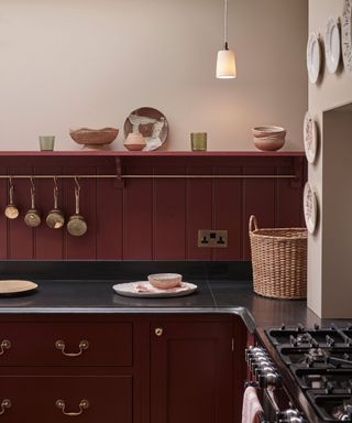 Burgundy in-frame kitchen cabinets with black countertops