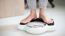 Close Up Of Woman Standing On Bathroom Scales At Home