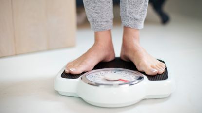 Close Up Of Woman Standing On Bathroom Scales At Home