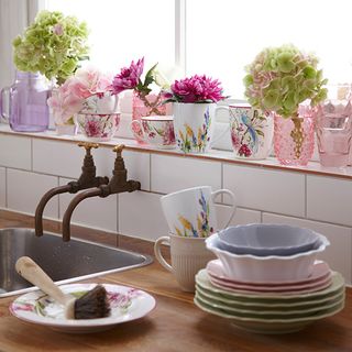 sink area with mugs and flowers and plates