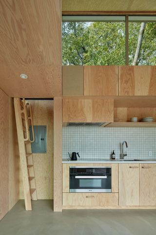 California guesthouse with wood kitchen and ladder to mezzanine