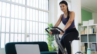 How to lose weight using an exercise bike: image shows woman on exercise bike