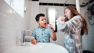 two siblings using an electric toothbrush