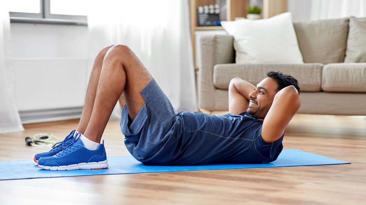 Man performs crunch in his living room