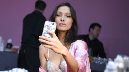 US model Bella Hadid poses for a selfie while getting ready backstage for the Victoria's Secret fashion show