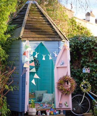 Playful shed in three-way pastels, with turquoise painted interior and floor; gentle blue exterior, and color contrast pink door interiors. Styled with seasonal decorations and bunting.