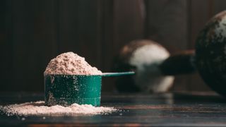 a scoop of protein powder next to a dumbbell