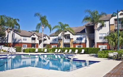 Condominium complex in the tropics with swimming pool, palmj trees and lush tropical foliage.