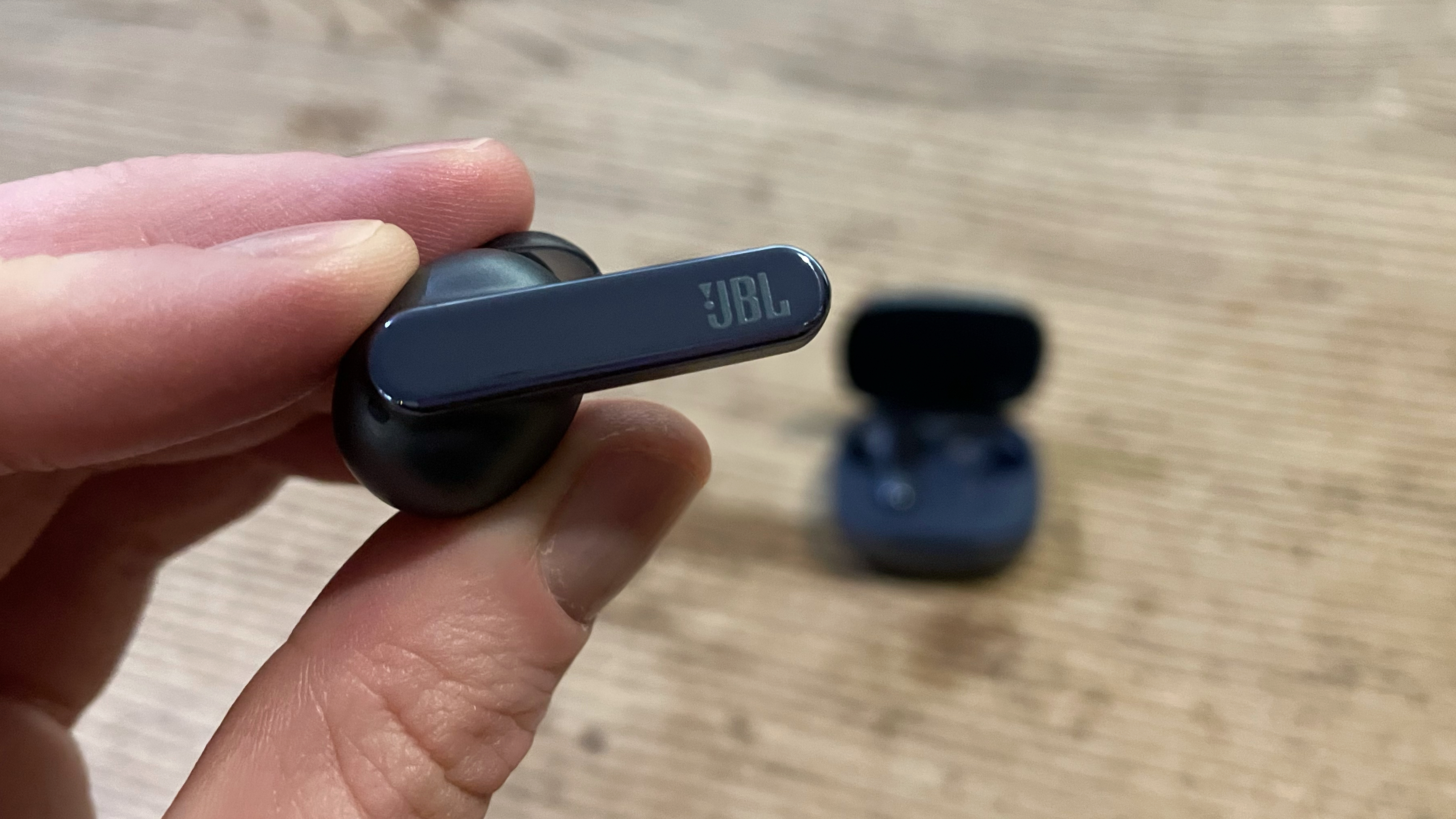 JBL Live Pro 2 earbuds held up to the camera