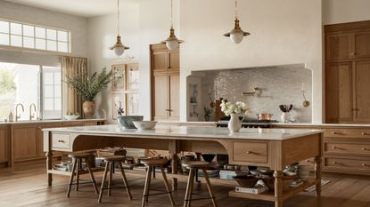 A large kitchen with white oak cabinets, marble countertops, and brass hardware