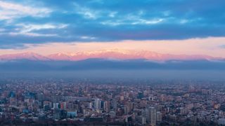 The skyline of Santiago de Chile, Chile's capital at sunset. A small part of the 5,530 mile-long Andes Mountains can be seen in the background.