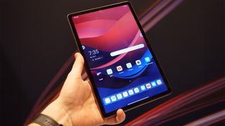 Lenovo Tab M11 tablet being held in front of a Lenovo backdrop at CES 2024