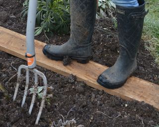 Working on a plank in winter to protect the soil