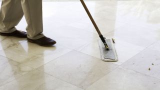 Man showing how to clean marble floors with mop