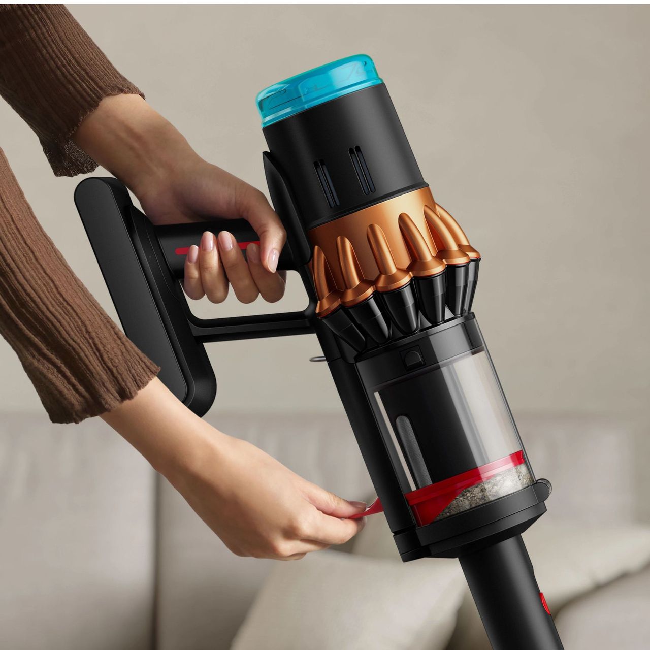 Hand pushing down the compaktor bin of the Dyson V16 Piston Animal