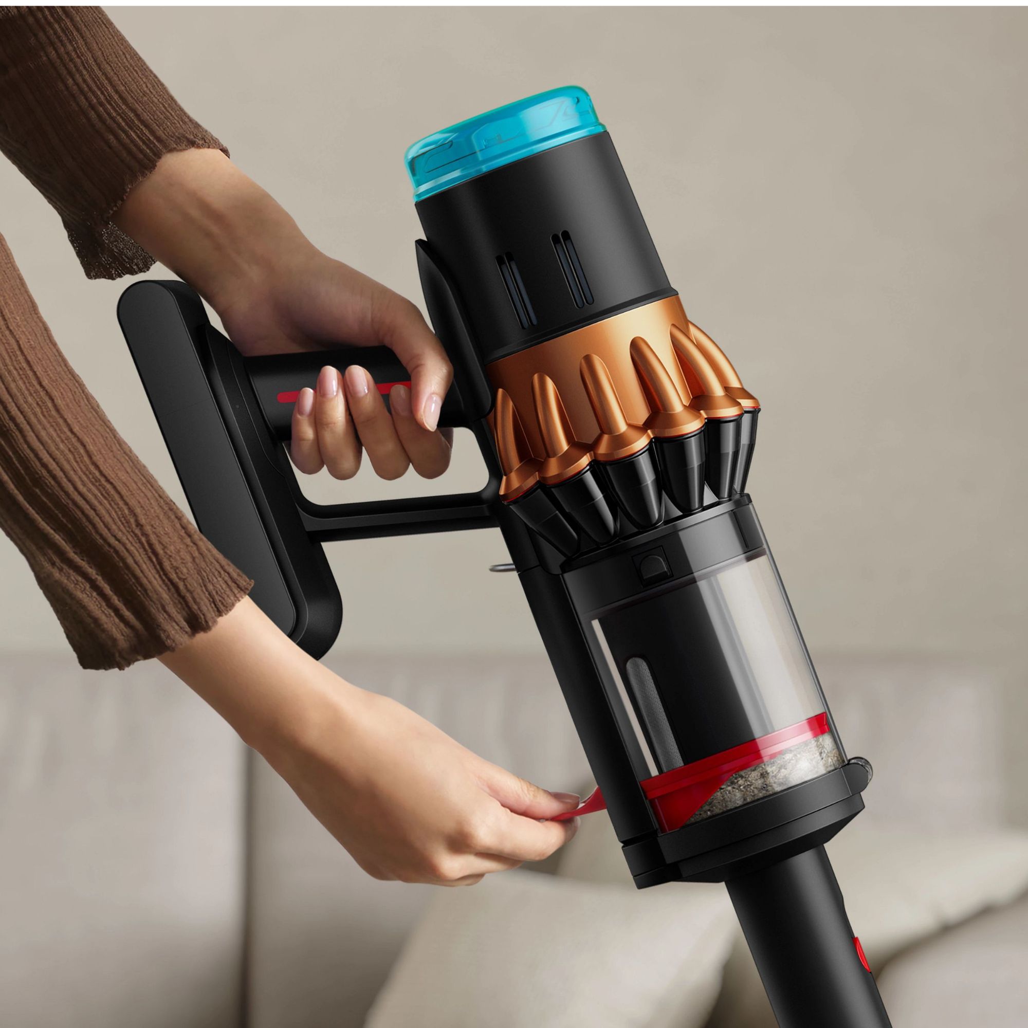 Hand pushing down the compaktor bin of the Dyson V16 Piston Animal