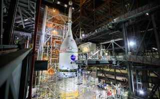 The Orion spacecraft for NASA’s Artemis I mission, fully assembled with its launch abort system, is lifted above the Space Launch System (SLS) rocket in High Bay 3 of the Vehicle Assembly Building at Kennedy Space Center in Florida on Oct. 20, 2021.