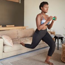 a woman using one of the best weights for home gyms - getty images 1286120041