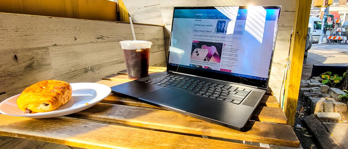 Razer Blade 15 on a table next to some coffee and a croissant