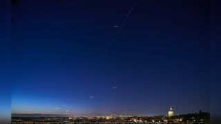 Planets Jupiter, Venus, Mars, Saturn and the Moon shine above Rome at dawn, while the Tianhe-1 Chinese space station crosses the sky on April 27, 2022.