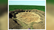 An excavated Stone Age house in Ukraine against a green and blue background