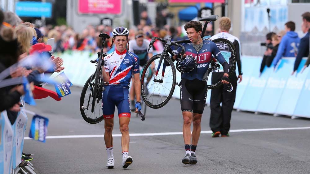 James Knox and Ian Bibby cross the line holding their bikes