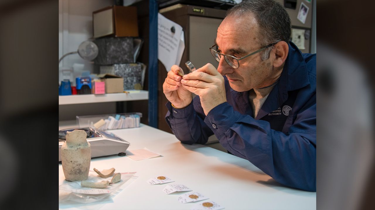 Coin expert Robert Kool examines one of the gold coins found in the juglet. The coins were so well-preserved that they were identifiable even without cleaning.
