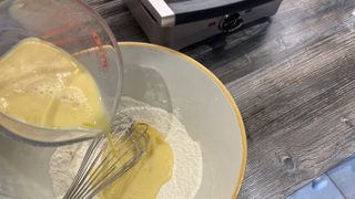 adding wet ingredients to dry ingredients for pancakes