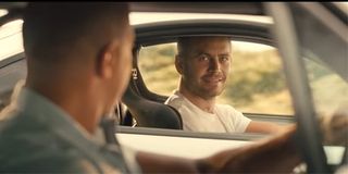 Brian O'Conner (Paul Walker) smiles at Dominic Toretto (Vin Diesel) from behind the wheel of his car