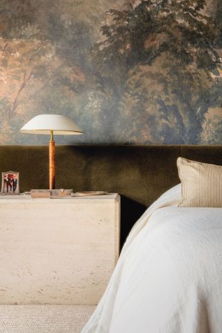 a bedroom with a large headboard and wallpaper
