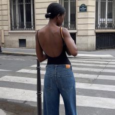 @sylviemus_ wears a pair of cropped wide leg jeans with a backless top