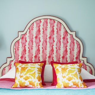 bedroom with pink headboard and blue wall
