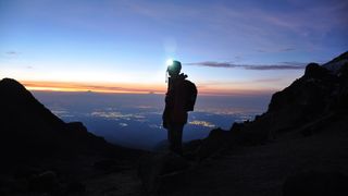 a photo of a hiker wearing a headtorch