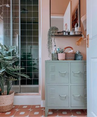 A small bathroom idea in green and pink with shower cubicle, retro floor tiles and green upcycled locker