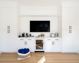 White kitchen with black handles and wood floor