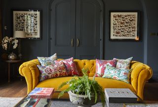 dark living room with yellow chesterfield