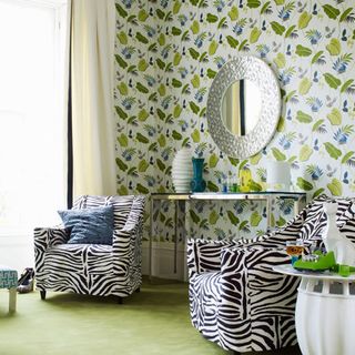 green room with patterned wallpaper and zebra chairs