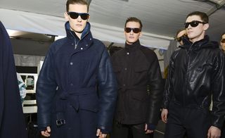 Male models wearing glasses and coats