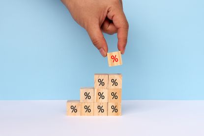 Hands Stacking Wood Toy Blocks with Percent Signs on