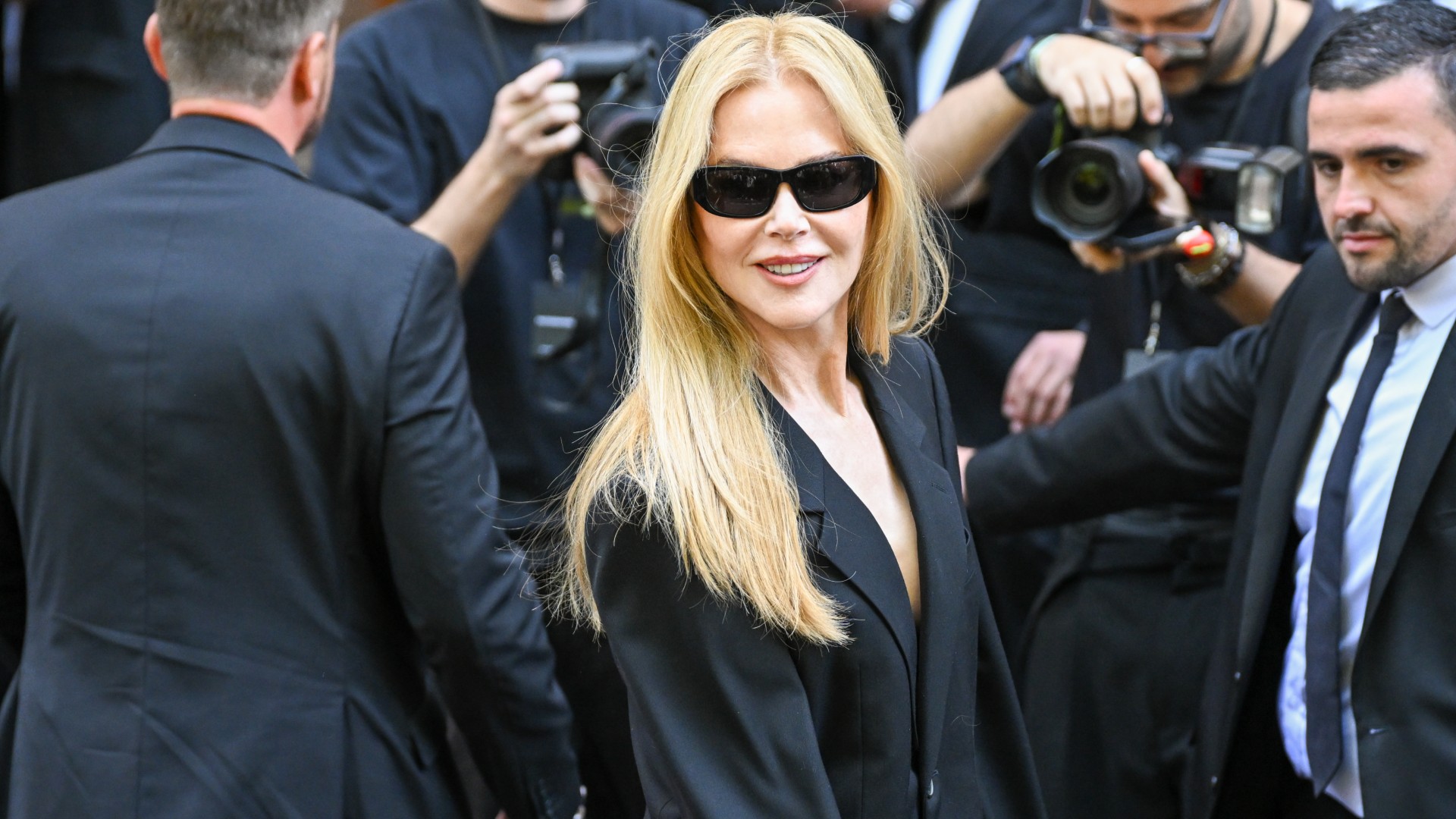 Nicole Kidman wearing an all-black suit and sunglasses