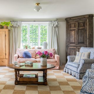 country living room with striped sofa and traditional armchairs